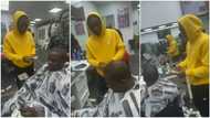 Young Nigerian man brings out wads of dollars from his pockets, sprays it all on his favourite musician at barbing salon