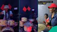 Nigerian lady with drumming skills delight young man wearing Manchester United jersey