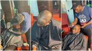 Photos & videos show man giving Davido haircut for his birthday, Nigerians comment about barber's skill
