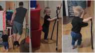 Funny baby boy copies the bent posture of his grandfather, uses walking stick like him in viral video