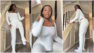 Nigerian lady in white socks & top lifts legs, shakes waist sweetly to song, gets men's attention