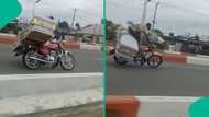 Young bikeman shows off riding skills while carrying huge coffin on highway, video goes viral online