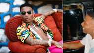 “You see wetin you don cause”: Wizkid blamed as fans force hands through window to receive dollars from him
