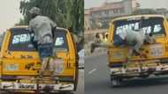 Na spirit dey function: Video captures man catching cruise on top of Danfo bus