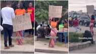 Pretty Nigerian lady takes to street in search of husband, carries cardboard in video, men rush her