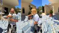 "People get money o": Wealthy lady fills her compound with bundles of cash, plays with money in video