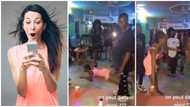 Nigerian lady in dress dances on her belly like snake at club, throws legs up in video, people stood up in awe