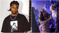 Female fan forcefully pulls Omah Lay down, Lays on him while performing on stage in Sweden, Nigerians react