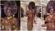 Beautiful ebony lady in brown asoebi ensemble sparks reactions among fashion lovers