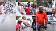 Desperate lady hits street dressed in wedding gown with a placard in search of a husband, says she has money
