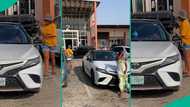 Lady waits for girls taking photos with her car to finish snapping before entering into vehicle