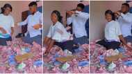 "Keep rich friends": Couple plays in pool of new naira notes after their wedding, stone each other in video