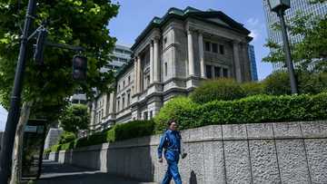 Bank of Japan holds rates, says to slow bond purchase taper