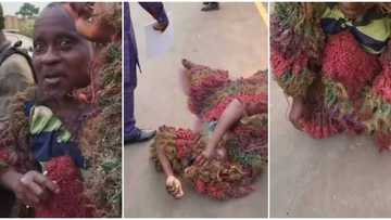 Masquerade unmasks, shows real face as he rolls on the floor begging for money in Owerri, video causes stir