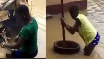 Reactions as a Nigerian ladies are seen cooking, pounding food inside Lagos flood