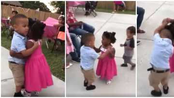 Little girl and boy hold hands and hug tightly as they dance like perfect couple before adults in cute video