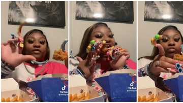 Video of lady eating chicken with extra long nails leaves internet users amused