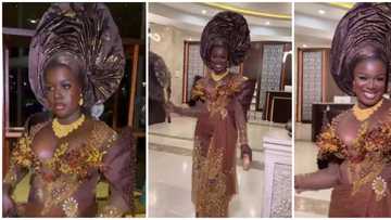 Beautiful ebony lady in brown asoebi ensemble sparks reactions among fashion lovers