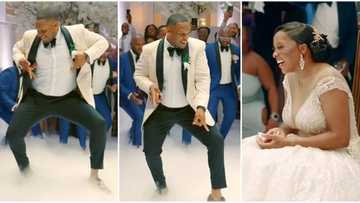 Handsome groom bends down low, uses his waist to dance like a lady, excited guests gather to watch in video