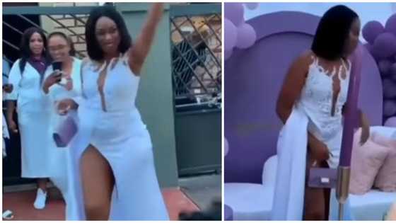 Nigerians react as woman with very high-slit dress struggles to cover herself in trending video