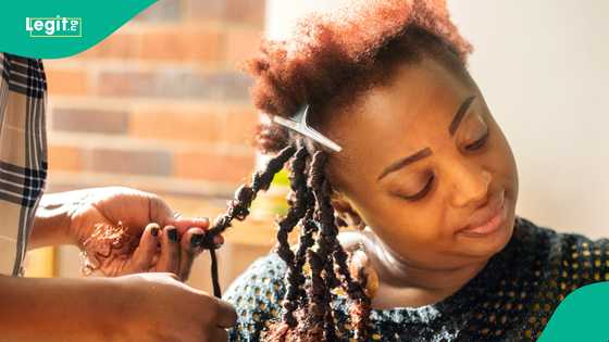 Woman expresses pain as she makes one million braids, peeps react: "She will carry it for 8 months"