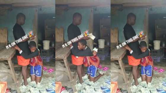 "I think say na dollar": Man sprays bundles of N20 notes on wife, lady holds his legs in video
