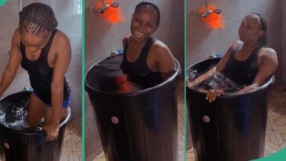 Lady dips herself inside big drum filled with cold water after she could not go to swimming pool