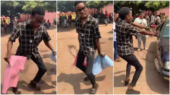 Young Nigerian student dances in crazy way while carrying placards, people record him with their phones