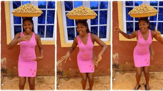 Groundnut seller in pink gown dances with large tray on her head, smiles happily in stunning video