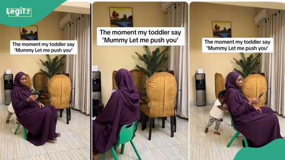 Mother and daughter play in the living room, she sits on her little girl’s chair as she drags it