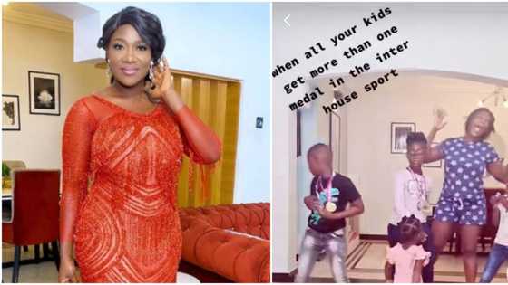 Proud Mercy Johnson dances excitedly around as she shows off kids with multiple medals from sports competition