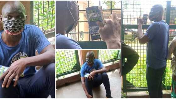Photos of Baba Ijesha holding on tightly to inspirational book on surviving hard times as he awaits hearing