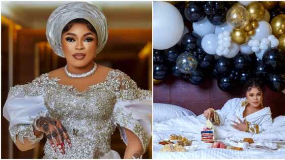 Bobrisky tensions Nigerians with birthday video, poses on bed with cake, several food and fruit platters