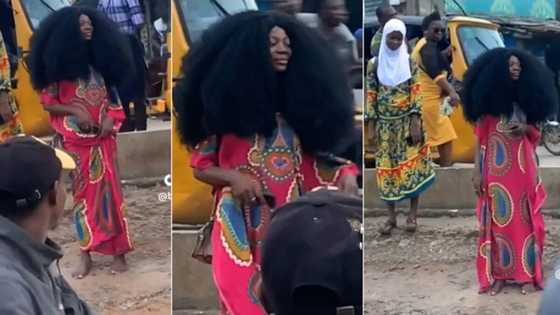 "She is not human": People gather as strange lady appears at Lagos bus stop in coloured gown, barefoot