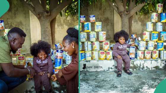 Nigerian man displays huge tins of milk his little daughter consumed at 2, does photoshoot with them