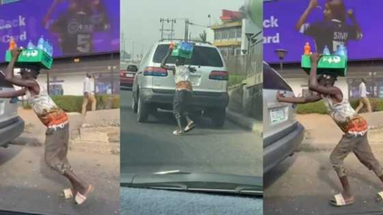 Reactions as Nigerian bottle water hawker helps push a car with one hand while balancing his goods on his head