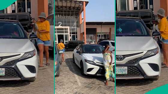 Lady waits for girls taking photos with her car to finish snapping before entering into vehicle